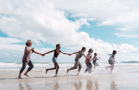 Asian family enjoying retirement and active lifestyle on the beach with kids and daughters, health, insurance, happiness, senior care, financial planning, and outdoor freedom.の写真素材
