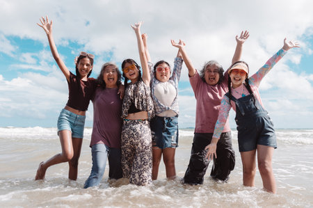 Healthy retirement lifestyle of Asian seniors with daughters and kids, enjoying joyful beach...