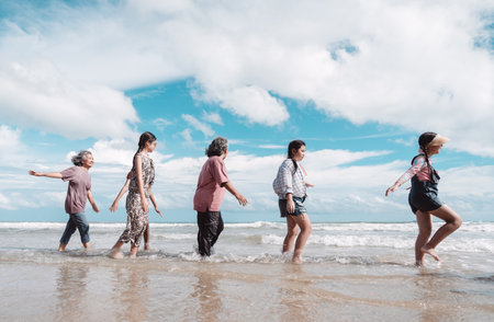 Asian family playing together retirement joy beach, healthy lifestyle, and fun activities. family insurance plan and active senior living.の写真素材