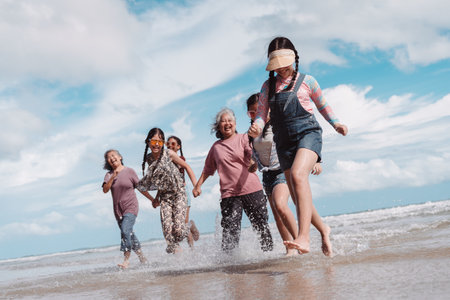Happy Asian family running the beach, Seniors and kids. joyful family travel, healthy retirement lifestyle, freedom, and outdoor wellness.の写真素材