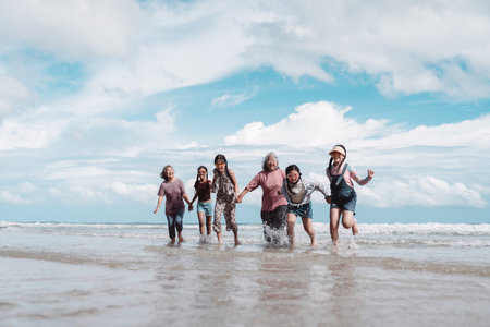Asian family enjoying retirement and active lifestyle on the beach with kids and daughters, health,...