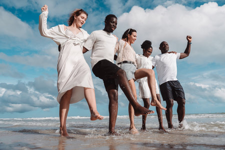 Happy diverse group of friends together on the beach, Active friendship, summer fun, positivity, and joyful lifestyle by the sea.の写真素材