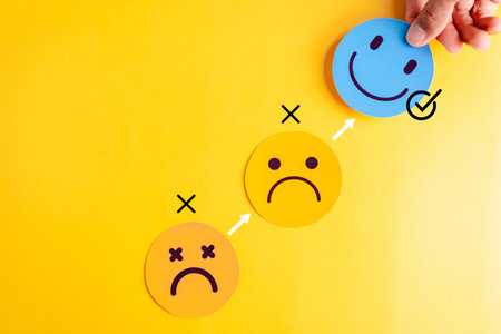 Blue smile face selected above sad expressions on yellow background, emotional clarity, mental...