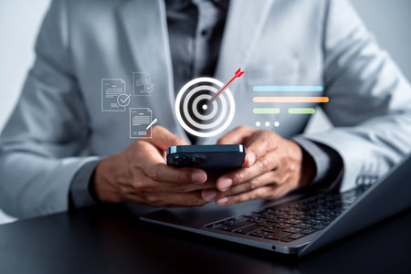 Businessman using smartphone with digital target and checklist, goal setting, workflow planning, task execution, productivity management, and strategic focus.の写真素材