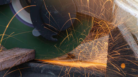 worker cutting metal with grinder