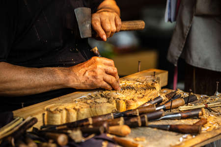 Wood carving working with hammerの写真素材