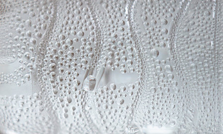 Water drops on a white plastic bottle. Abstract background and texture for design.