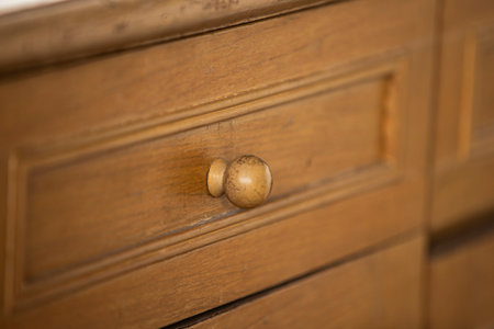 Close up of a wooden chest of drawers with a brass handleの写真素材
