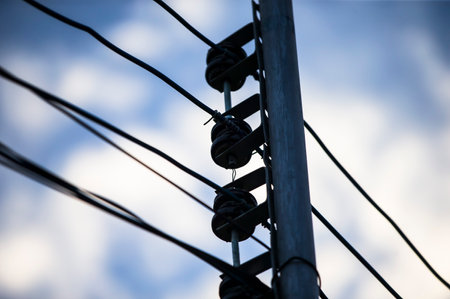 Electricity post with blue sky in the background, close up.の写真素材