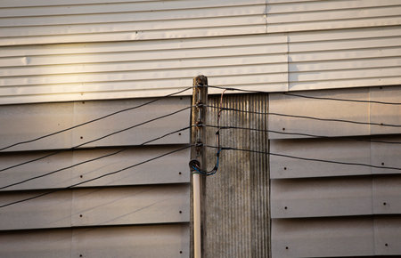 electricity post with wire on the roof of a building in the eveningの写真素材