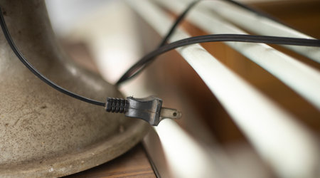 Electrical cable connected to a heating radiator. Close-up.の写真素材