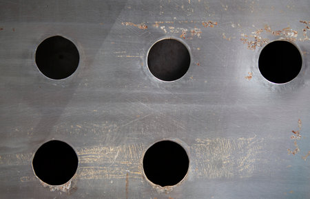 grunge metal plate with round holes, industrial background, texture