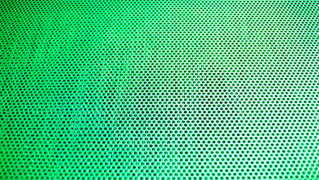 Green metal background with holes. Texture of metal sheet with holes.の写真素材