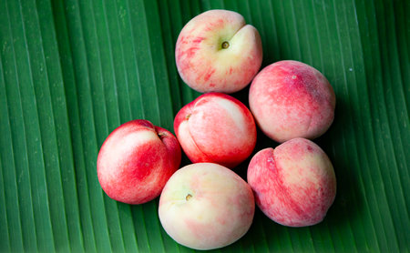 Peaches on a banana leaf, close-up, selective focus
