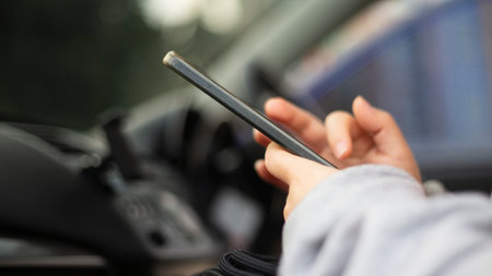 Close-up image of a woman using mobile phone in the car