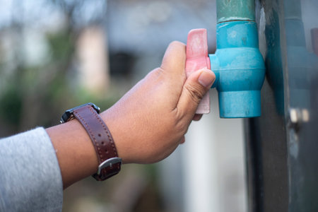 Hand of a man cleaning the door handle with water pipeの写真素材