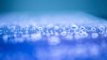 Water droplets on a blue background. Shallow depth of field.
