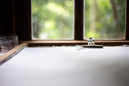 Wooden table with paper sheet on the window sill.