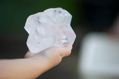 Ice cubes in hand, shallow depth of field with selective focus.の写真素材