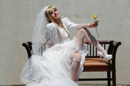 pretty new bride posing holding yellow rose.の写真素材