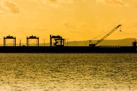 Silhouette of the dam at colorful sunset and over color. With parking Heavy machineryの写真素材