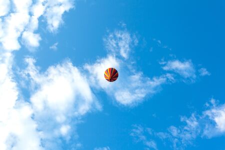 Hot air Balloon flying high and blue sky seen from underの写真素材