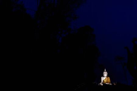 Big white Buddha statue on evening time in dark background with copy spaceの写真素材