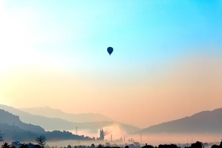 Soft focus misty mountain forest and hot air balloon landscape in morning time