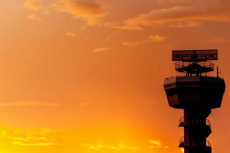 Silhouettes of radar tower on sky background at sunriseの写真素材