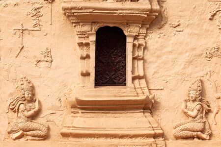 Ancient stucco sculptureon the carving on temple wall in Laosの写真素材