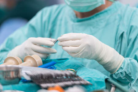 Scrub nurse preparing tools for operation