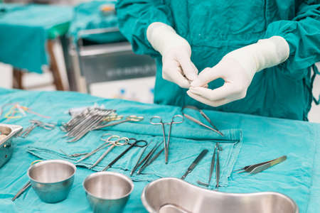 scrub nurse preparing tools for operationの写真素材