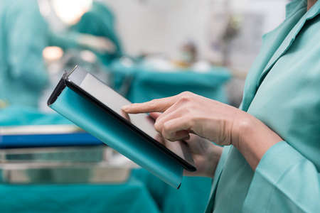 surgeon using digital tablet in operation roomの写真素材