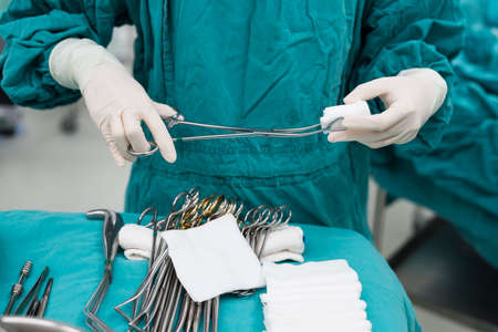 scrub nurse preparing tools for operationの写真素材