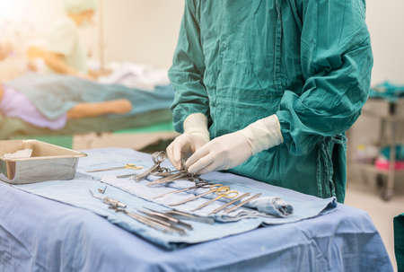 scrub nurse preparing medical instruments for operation