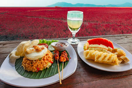 Fried rice and fruit on the table Red grasslandの写真素材