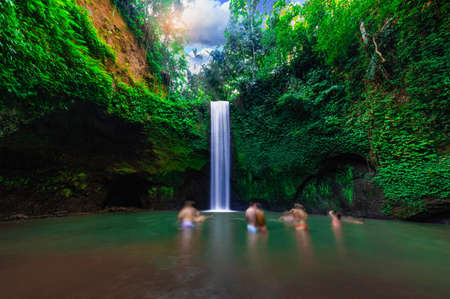 Tourist visits Tibumana waterfall which is famous place & top travel destination in Bali,Indonesia.(Blur the tourist image)の写真素材