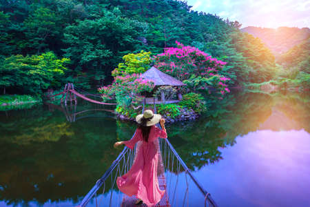 Asian woman walks on a red bridge to an island resort in Suncheon, South Korea.の写真素材