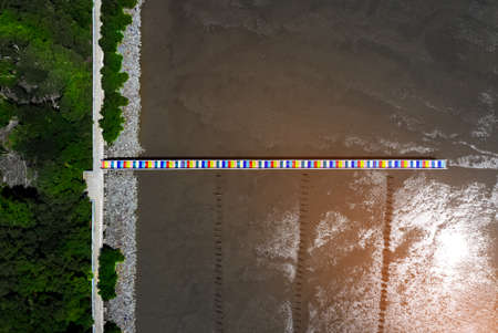 Rainbow bridge in Thailand.View of The colorful wood bridge extends into the sea at samut sakhon province,Thailand,Aerial viewの写真素材