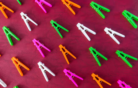 Colorful set of decorative plastic clothespins on a red backgroundの写真素材