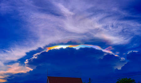 Iridescent  Pileus cloud on the sky before the sun set at Thailandの写真素材