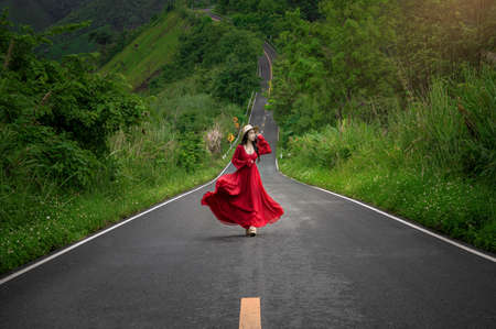 Asian woman walking on Beautiful sky road over the top of mountain and green forest in Pua, Nan, Thailandの写真素材