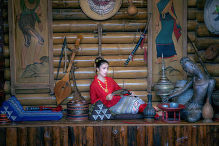 Thai women dressed in Thai Lanna costumes sitting in front of important tourist sites in Nan province, Thailandの写真素材