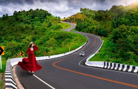 Asian tourist woman walking alone on country road rear view. Number three of road among the...