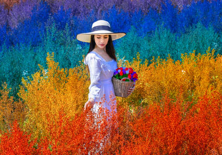Beautiful Thai woman stangding among the cutters flower in rainbow colors in Chiang Mai province, Thailandの写真素材