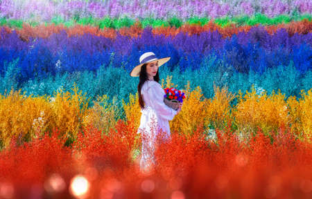 Beautiful Thai woman standing among the cutters flower in rainbow colors in Chiang Mai province, Thailandの写真素材
