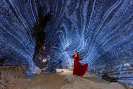 Asian woman in a red dress visits a blue cave in Tak Province, Thailandの写真素材