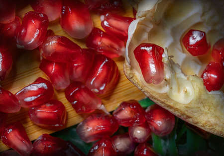 Ripe pomegranate with juicy seeds, on  wooden tableの写真素材