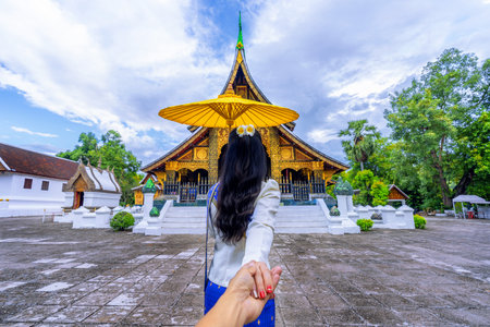 Asian woman wearing a Lao national costume visits Wat Xieng Thong in Luang Prabang, Laosの写真素材