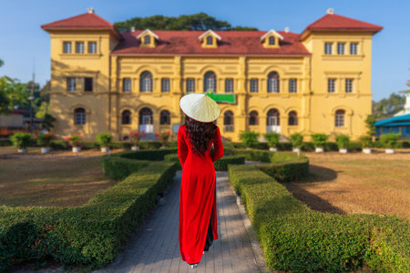 A young Vietnamese tourist in a red national costume visits the old library in Nakhon Phanom Province, Thailand.の写真素材